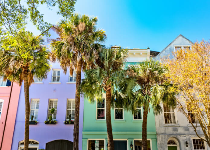 Downtown Charleston South Carolina featuring palmetto trees in front of Rainbow Row houses