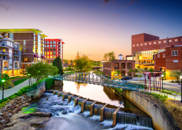 Downtown Greenville South Carolina at Dusk featuring a pedestrian bridge over the river